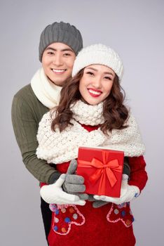 Handsome young man giving present to beautiful woman. Christmas time.