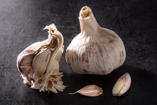 Fresh organic garlic on black slate background