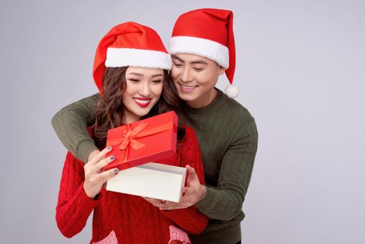 Handsome young man giving present to beautiful woman. Christmas time.