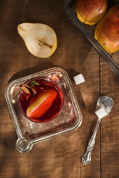 homemade hot mulled pear cider with a cinnamon stick on a wooden background 