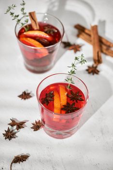 Orange cocktail with rum, liquor, pear slices and thyme on white table, selective focus