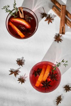 Orange cocktail with rum, liquor, pear slices and thyme on white table, selective focus