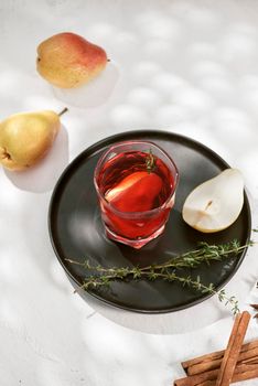 Delicious spicy hot mulled red wine with cinnamon, star anise and slice pear served in a carafe and glass for a cold winter evening or festive Christmas beverage