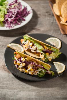 Traditional mexican taco with chicken and vegetables on wooden table. Latin american food. 