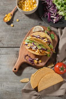 Traditional mexican taco with chicken and vegetables on wooden table. Latin american food. 
