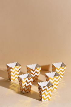 Empty paper golden Christmas cups for winter holidays meetings with friends with New Year"s Christmas decor on a beige background