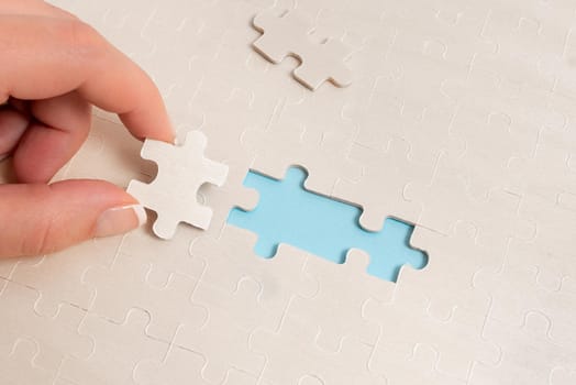 Building An Unfinished White Jigsaw Pattern Puzzle With Missing Last Piece