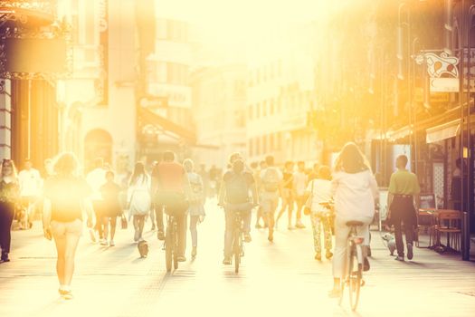 Blurred crowd of people on Copova pedestrian street in Ljubljana at sunset. Urban lifestyle and mobility concept