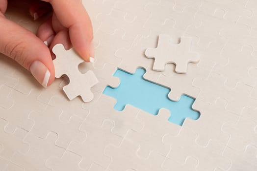 Building An Unfinished White Jigsaw Pattern Puzzle With Missing Last Piece