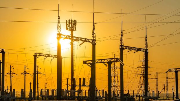 Production of fuel and electricity.Electrical networks with wires and transformers at sunset.Power transmission lines and from the power plant.Power lines with wires under voltage and electric current