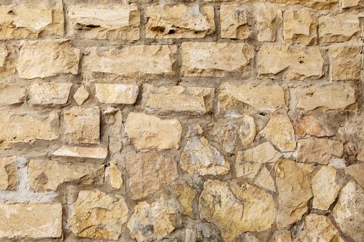 Close-up of a fragment of an old natural white limestone wall.