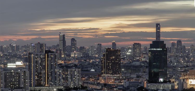 Bangkok, Thailand - Jun 05, 2021: Panorama shot of sunset at Bangkok city skyline. Beautiful scenery view of Skyscraper at night, Selective focus.