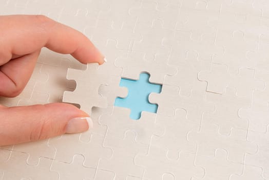 Building An Unfinished White Jigsaw Pattern Puzzle With Missing Last Piece