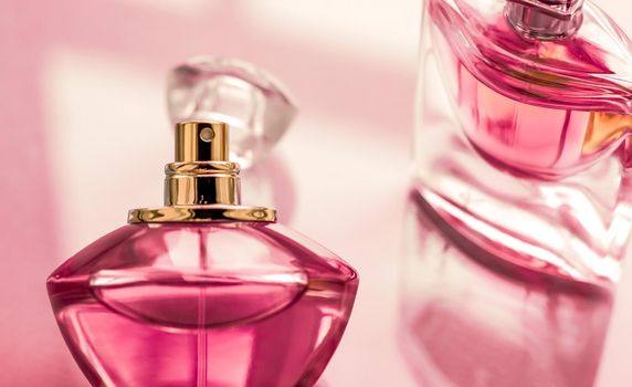 Perfumery, spa and branding concept - Pink perfume bottle on glossy background, sweet floral scent, glamour fragrance and eau de parfum as holiday gift and luxury beauty cosmetics brand design