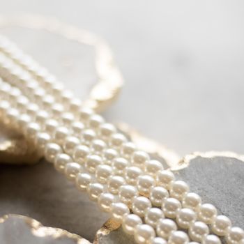 Pearl necklace on golden marble, ethical jewellery - luxury background, jewelry as a gift concept. Pearls are girl's best friends