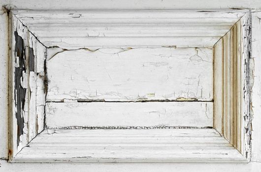 White paint cracks to reveal rotten wood underneath