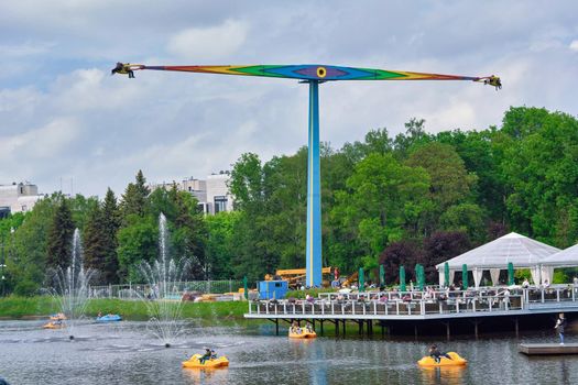 Saint Petersburg, Russia - June 12, 2021: People ride attractions in the city park in St. Petersburg