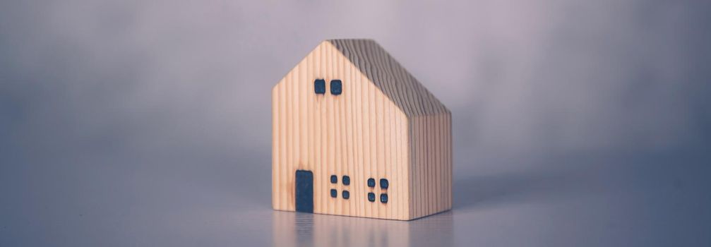 Mini wooden home model concept, investment of real estate and asset, tax of property and rental for finance, no people, small house and inspiration, mortgage and loan for residence, business concept.