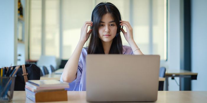 A girl practice basic course exercises by video on laptop before online class. Social distancing.stay home. New normal. Covid-19 coronavirus concept