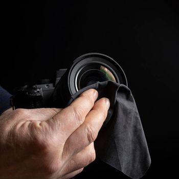 a man cleaning the front lens of a camera lens