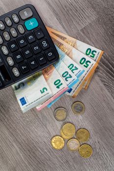 euro money and calculator on wooden background