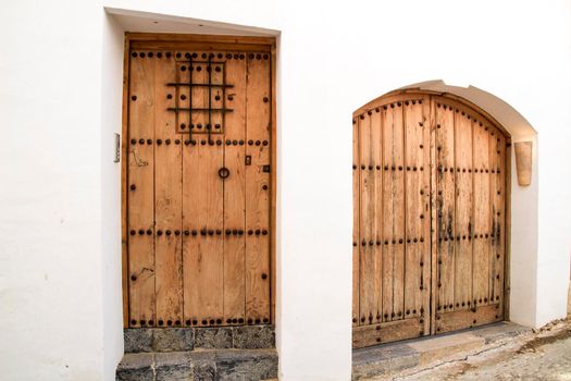 Beautiful whitewashed facade with old wooden door with iron details in Altea village, Alicante, Spain