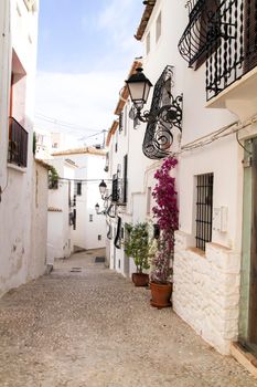 Beautiful whitewashed facade with colorful bougainvillea plant in Altea village, Alicante, Spain