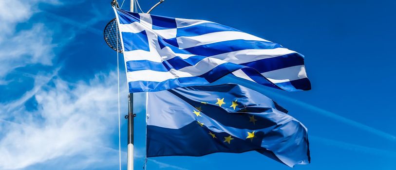 European political news, grexit and nation concept - Flags of Greece and European Union on blue sky background, politics of Europe