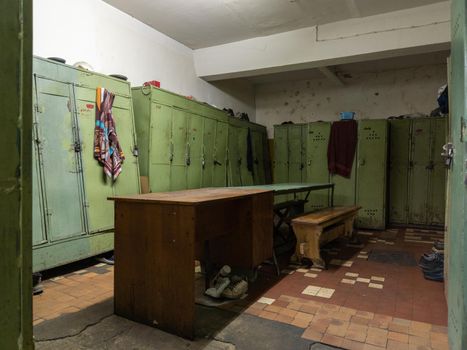 old dirty locker room in soviet factory with table and benches