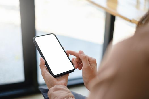 A woman hand holding smartphone device with blank screen