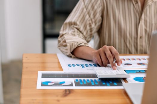 Close up Business accounting concept, Business man using calculator with computer laptop, budget and loan paper in office.