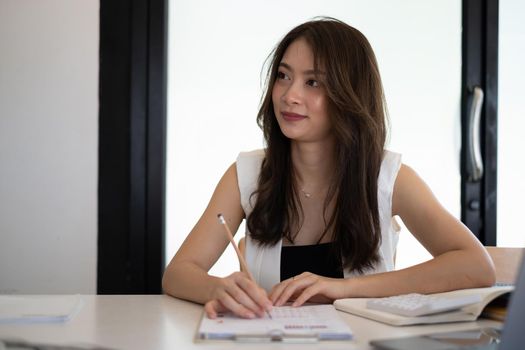 Beautiful secretary listening and taking note at meeting room