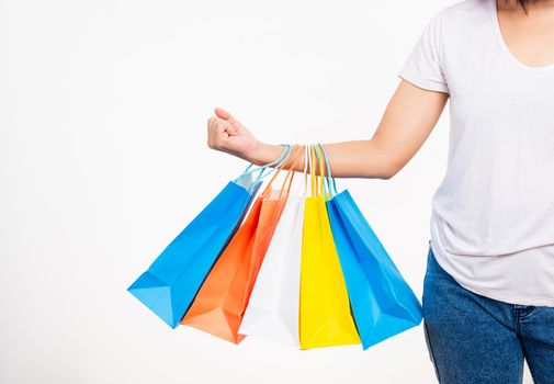 Happy woman hand holding shopping bags multicolor, young female hold many packets within arms isolated on white background, Black friday sale concept