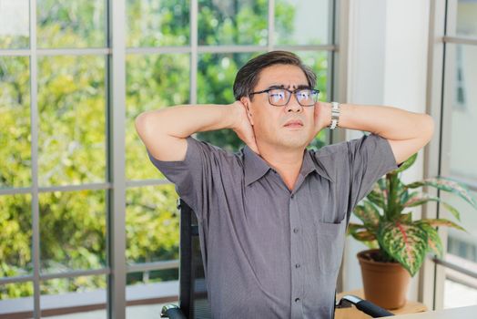 Asian hard senior businessman working with laptop computer has a problem with neck pain. Old man feeling pain after sitting at desk long time, Healthcare and medicine office syndrome concept