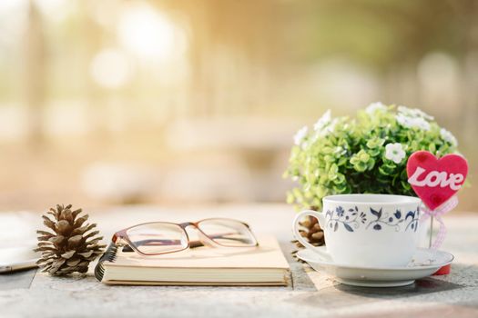 Close-up of empty notebook,spectacles and cup of coffee on Marble floor background. Love concept with heart desktop,Valentine's Day.