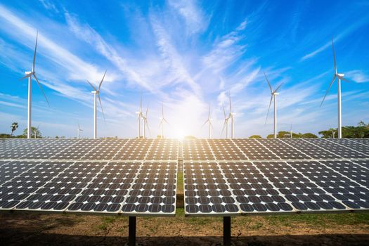 solar panels with wind turbines against mountanis landscape against blue sky with clouds,Alternative energy concept,Clean energy,Green energy.