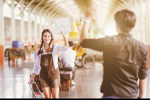 Asian woman pregnant Hold map say goodbye With a young man in at in a train station