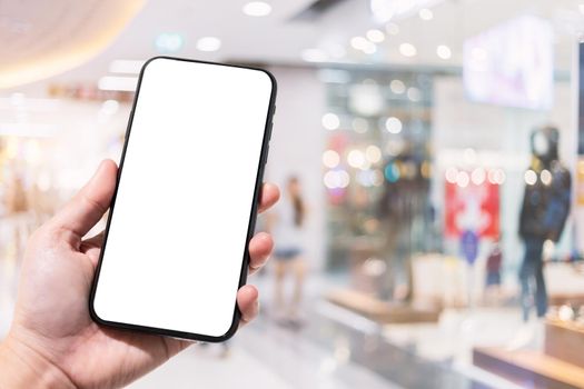 Close-up of female use smartphone blurred images in the mall and Clothes shop blur of the background.