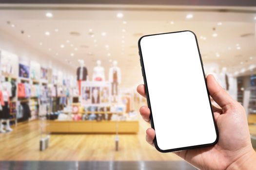 Close-up of female use smartphone blurred images in the mall and Clothes shop blur of the background.