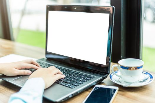 Close-up of Business woman working with smartphone,laptop with blank white screen and document in coffee shop like the background.