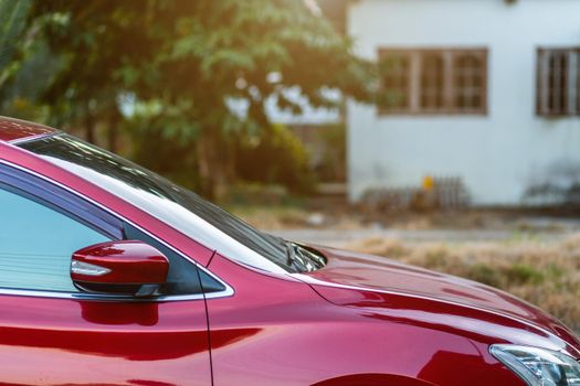 Closeup of headlight ,window of red car outdoors.