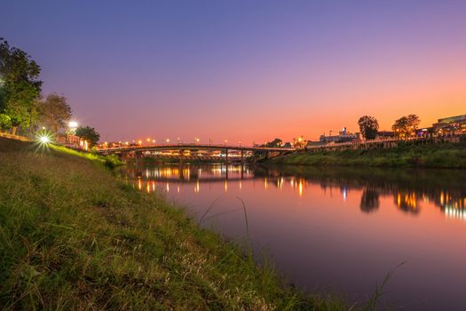 Beautiful White grass grass view the Nan River and the bridge (Eka Thot Sa Root Bridge) at sunset in Phitsanulok City, Thailand.