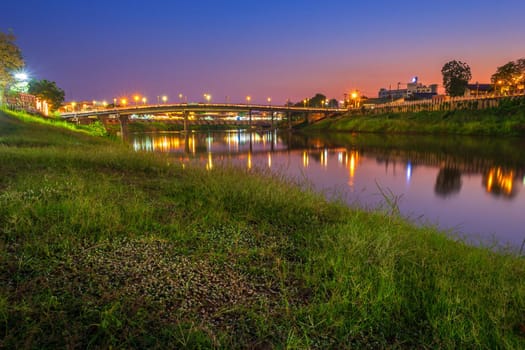 Beautiful White grass grass view the Nan River and the bridge (Eka Thot Sa Root Bridge) at sunset in Phitsanulok City, Thailand.