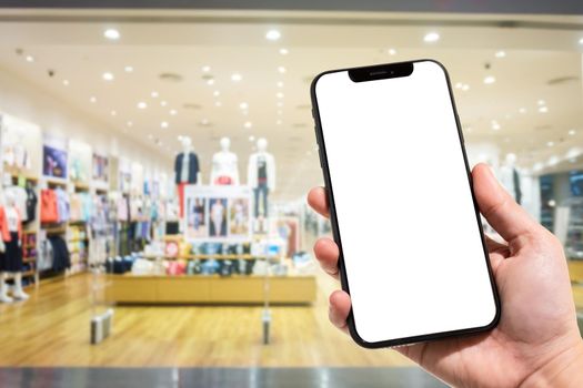 Close-up of female use smartphone blurred images in the mall and Clothes shop blur of the background.