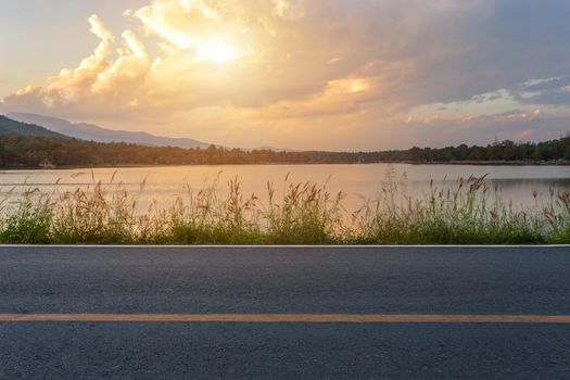 Rural road with Scenic view of the reservoir Huay Tueng Tao with Mountain range forest at evening sunset in Chiang Mai, Thailand