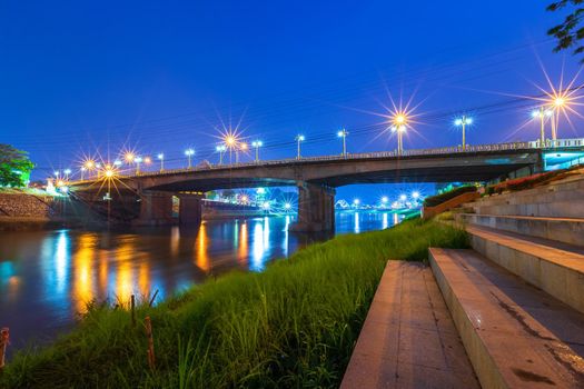 Beautiful light on the Nan River at night on the bridge (Naresuan Bridge) in Phitsanulok City,Thailand.