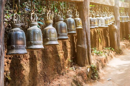 Old bell hangs on steel rail in The stone with the footprint of Lord Buddha at Khitchakut mountain It is a major tourist attraction Chanthaburi, Thailand.