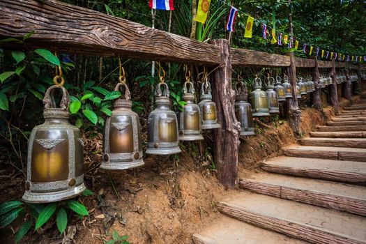 Old bell hangs on steel rail in The stone with the footprint of Lord Buddha at Khitchakut mountain It is a major tourist attraction Chanthaburi, Thailand.