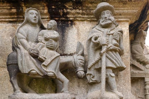 Guimiliau Parish close - Flight into Egypt, detail of scene on the Calvary in Parish close Guimiliau, Brittany, France