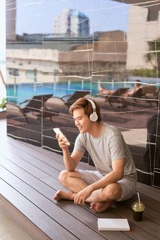 Summer sunny day, cheerful attractive smile asian man uses the smartphone